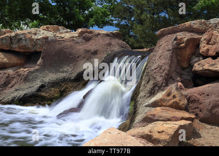 Artificial waterfall in Piney Creek East Park, Colorado, at bright sunny day. Long exposure. Stock Photo