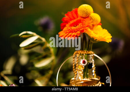 Close-up of Colorful Flowers Decorated with Jewellery Stock Photo