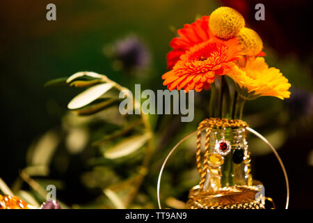 Close-up of Colorful Flowers Decorated with Jewellery Stock Photo
