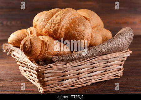 Delicious croissants in wicker basket on table close-up Stock Photo