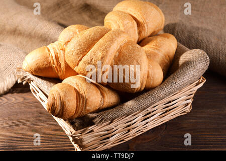 Delicious croissants in wicker basket on table close-up Stock Photo