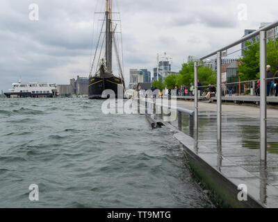 Toronto, Canada. 15th June, 2019. Toronto tall ship Kajama is docked at quay with Obsession III motor yacht in background on a cloudy day. Stock Photo