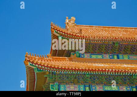 Looking up at the colourful roof of a traditional Chinese building in the Forbidden City (Beijing). Orange tiles with little carvings of mythical anim Stock Photo