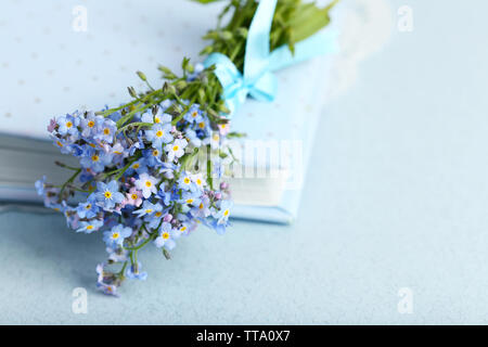 Forget-me-nots flowers on book, on blue background Stock Photo