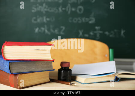 Teachers workplace  on blackboard background Stock Photo