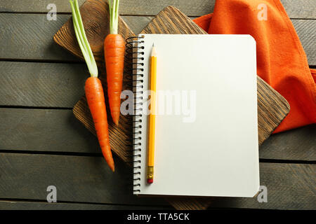 Open recipe book, vegetables on wooden background Stock Photo