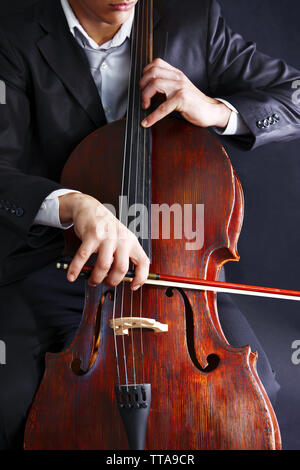 Man playing on cello on dark background Stock Photo