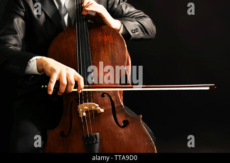 Man playing on cello on dark background Stock Photo