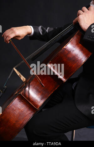 Man playing on cello on dark background Stock Photo