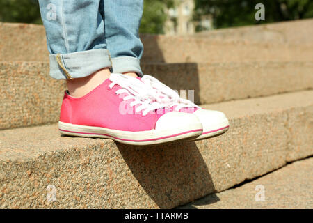 Long Woman Legs On White Pink Gumshoes On Side View Stock Photo