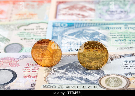 Nepalese Rupee coins on the background of banknotes Stock Photo