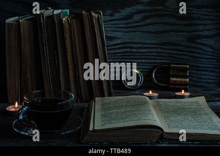A Cup of coffee and laid out the book on the table with candles Stock Photo