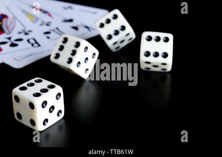 Dice, playing cards on a black background thrown on the table Stock Photo