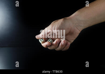 Male hand throwing dice on a black background Stock Photo