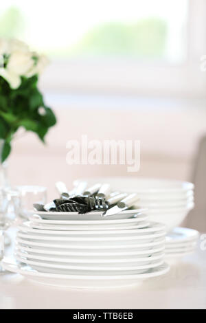 Clean plates, glasses and cutlery on white table Stock Photo