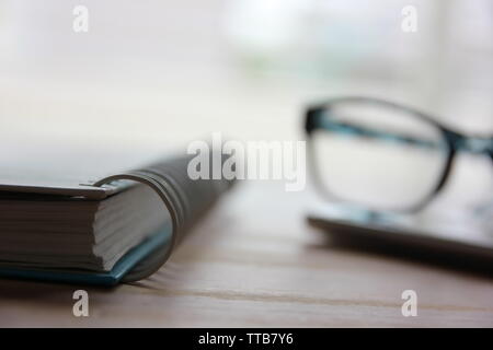 diary with spectales on smartphone in office Stock Photo