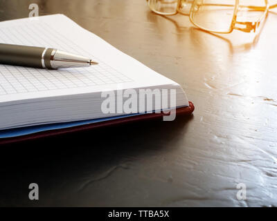Open note pad with pen and glasses. Reminder on the desk. Stock Photo