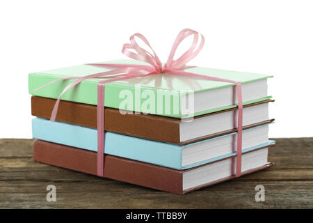 Stack of books with ribbon on light background Stock Photo