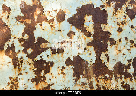 Old rusty metal surface is covered with peeling paint Stock Photo