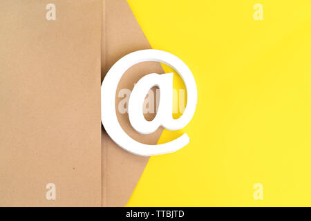 brown envelope with e-mail sign on yellow background Stock Photo
