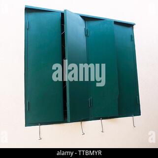 Closed Green Wooden Window with Shuttered on The Wall. Stock Photo