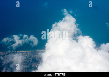 Arial view from internal cabin of aeroplane.Clouds in the sky and cityscapes though airplane window. Stock Photo