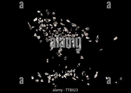 Split debris of stone exploding against black background. Stock Photo