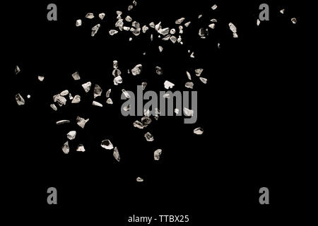 Split debris of stone exploding against black background. Stock Photo