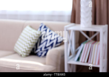Comfortable sofa  with different pillows in the room, unfocused Stock Photo