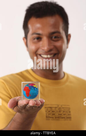 Man showing a paperweight and smiling Stock Photo