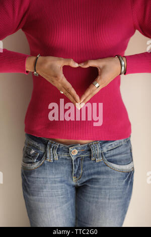 Woman making heart shape with hands Stock Photo