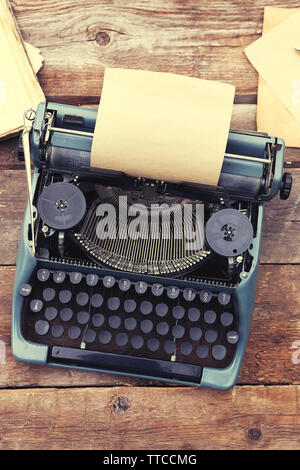 Vintage black typewriter with papers and pen on wooden table, outdoors Stock Photo