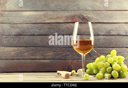 A glass of white wine and green grapes on wooden background Stock Photo