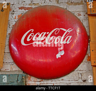 Classic red Coca Cola button sign in a hardware store in North Carolina Stock Photo