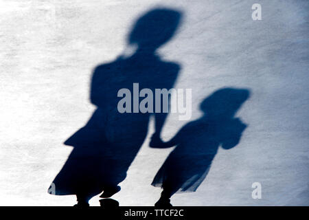 Blurry vintage shadows silhouettes of two female person walking  in black and white night