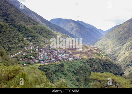 Village and rice terraces perched on the cliff over the Talubin river in Bayyo near Bontoc, Philippines Stock Photo