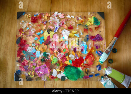 Palette of the artist with tubes of paint and brushes. Close up. Textured colorful art background. Stock Photo