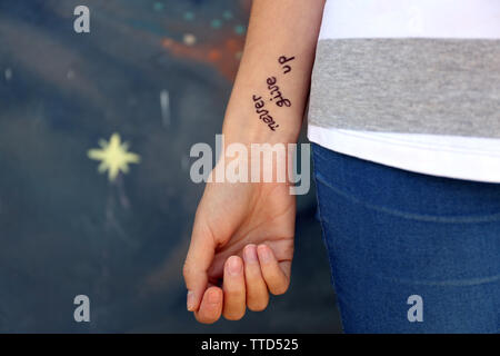 Female hand with tattoo on wall background Stock Photo