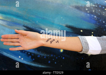 Female hand with tattoo on wall background Stock Photo