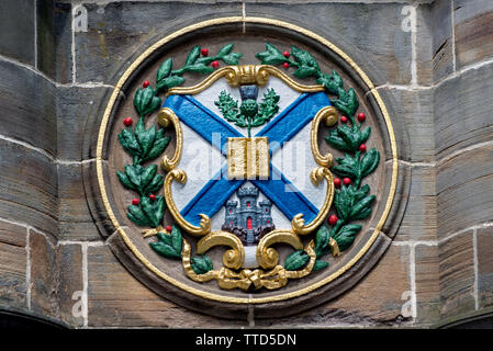 The arms of Edinburgh University on the Mercat Cross in Parliament Square on the High Street in the Old Town of Edinburgh. Stock Photo