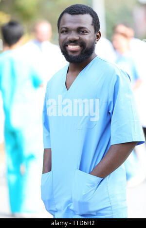 Portrait of an handsome smiling doctor on blurred background Stock Photo