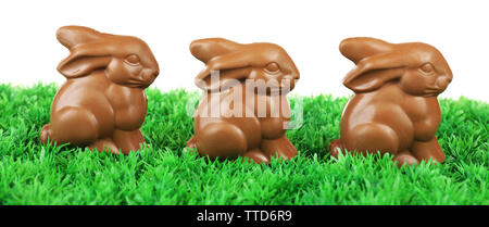 Chocolate Easter bunnies on green grass, on white background Stock Photo