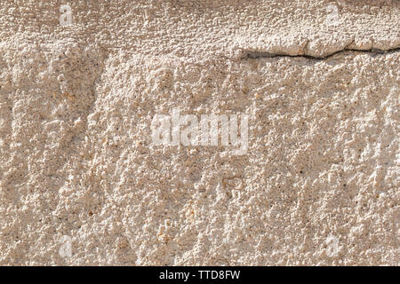 Ancient concrete wall with cement brown coating. A large crack in the upper left corner. Destruction of a worn building structure Stock Photo