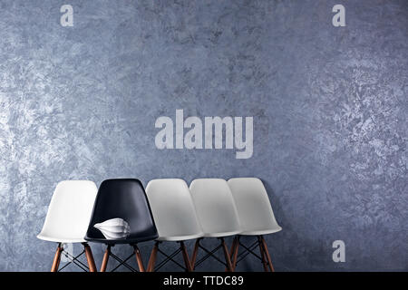 Stylish conception with white and black chairs on grey background Stock Photo