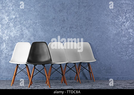 Stylish conception with white and black chairs on grey background Stock Photo