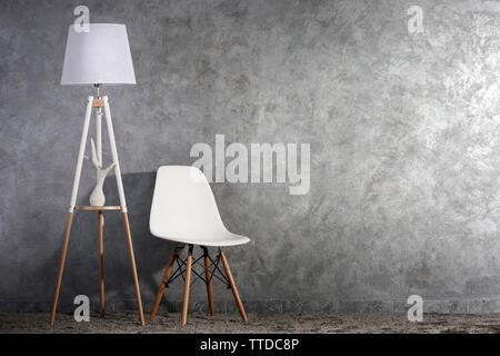 Stylish conception with chair and lamp on grey background Stock Photo