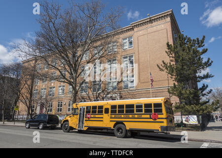 School bus parked outside a New York City Public Elementary School in Brooklyn, New York. Stock Photo