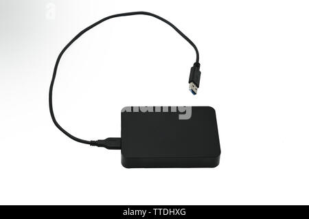 Portable hard drive for backing up various files on an isolated white background Stock Photo