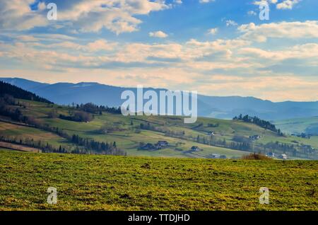 Beautiful rural mountain landscape. Cottages in the countryside on the hills. Stock Photo
