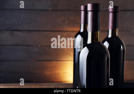 Wine bottles on the table against wooden background Stock Photo